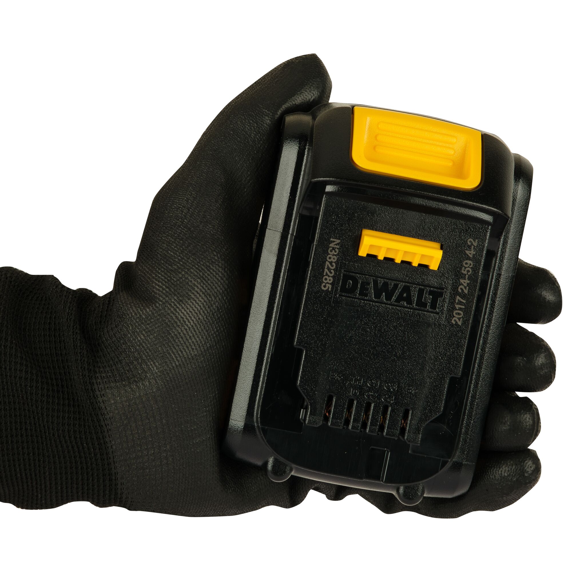 A black gloved hand holding a DEWALT DCB181 battery pack, showing the connectors and yellow release button.