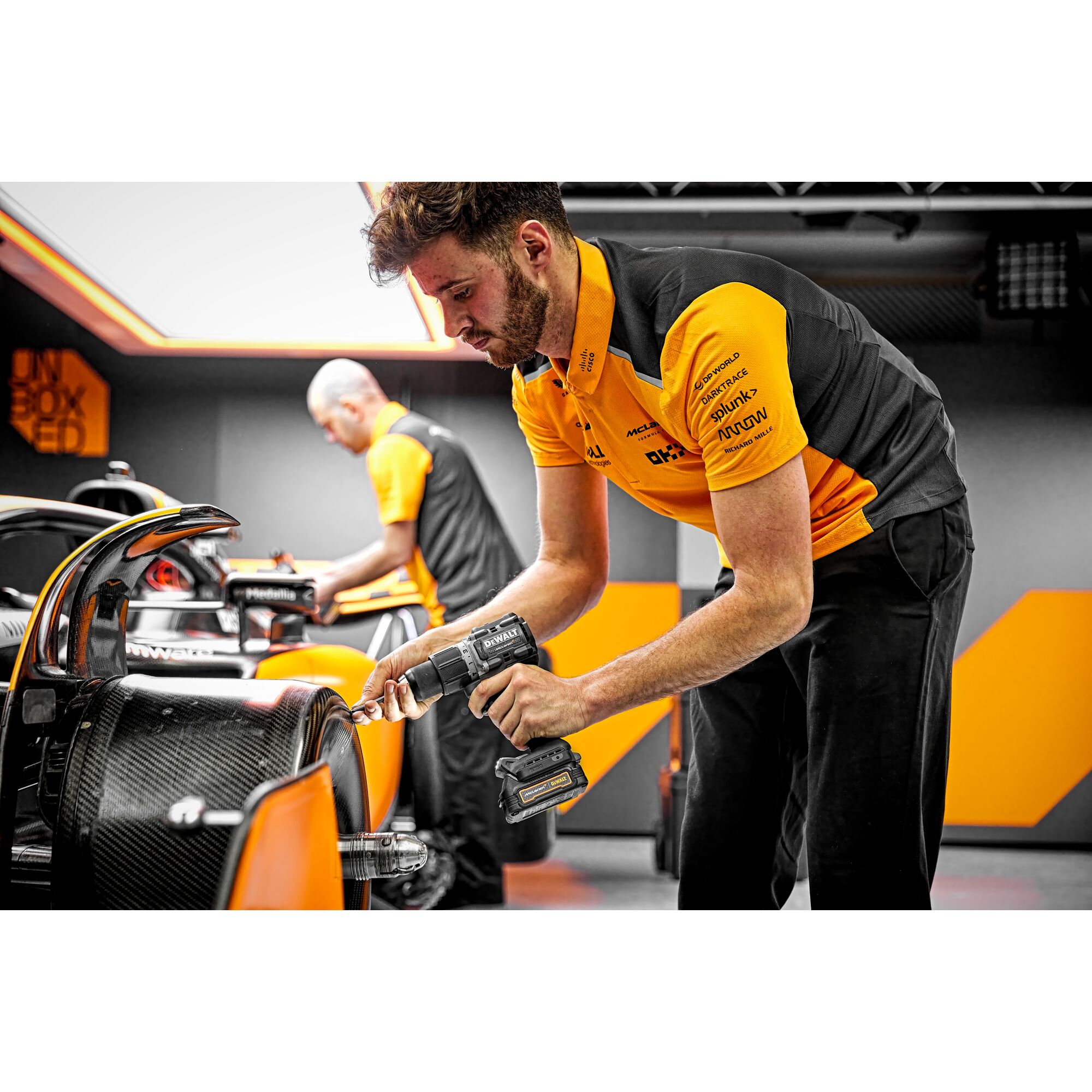 Close view of Limited Editon DEWALT/McLaren Drill Driver being used by pit crew on a McLaren F1 car