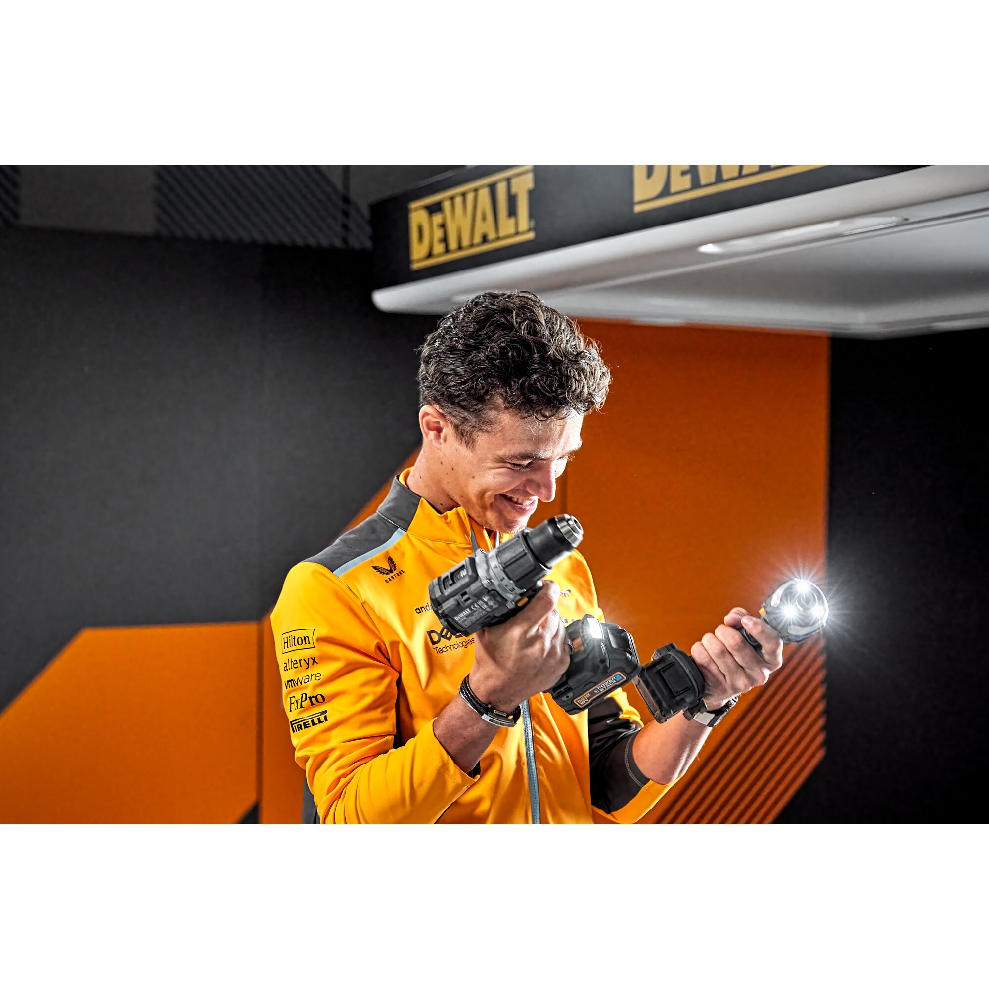 McLaren driver Lando Norris holding Limited Editon DEWALT/McLaren Drill Drivers with tool lights on 