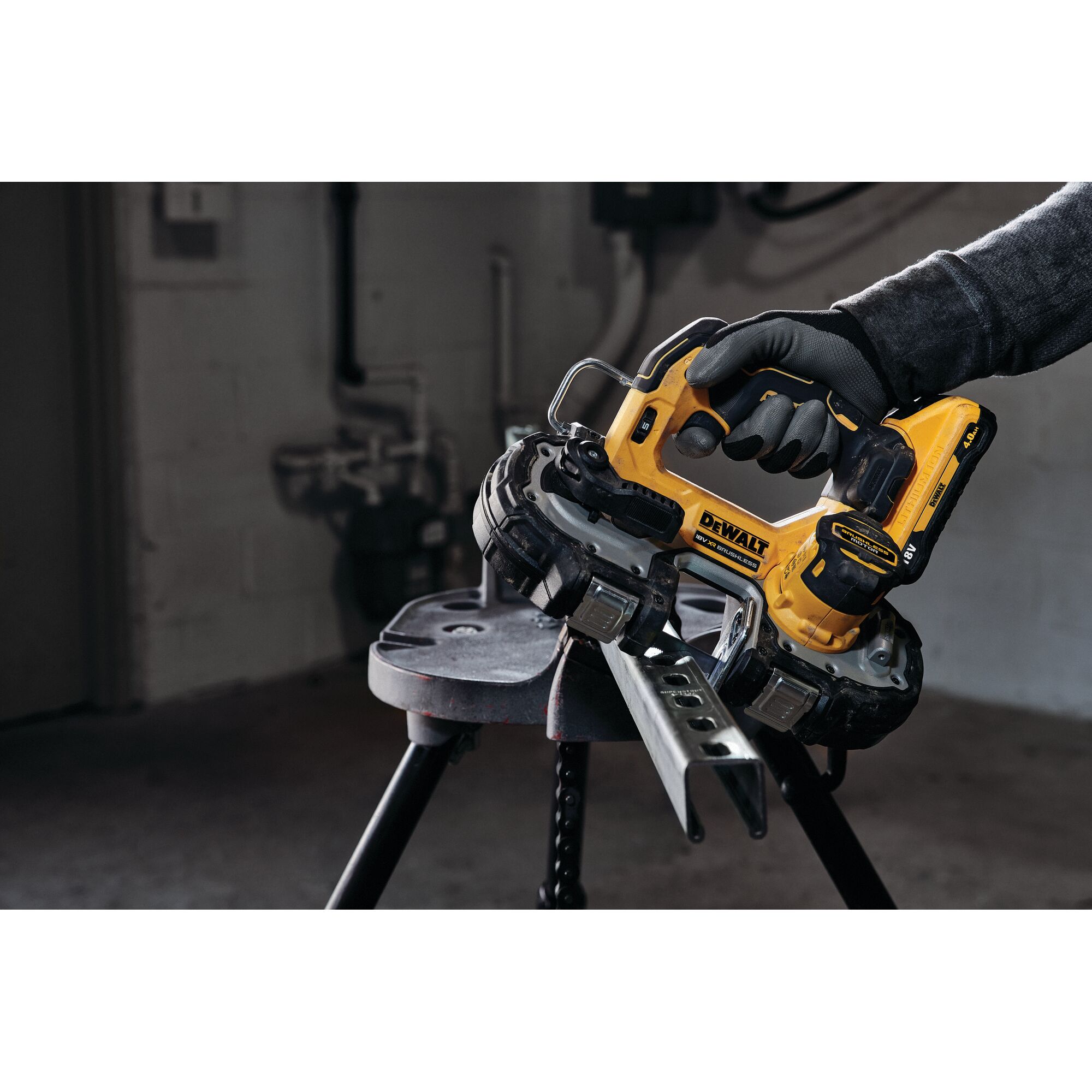 DEWALT cordless bandsaw cutting a metal piece, operated by a gloved hand in a workshop.