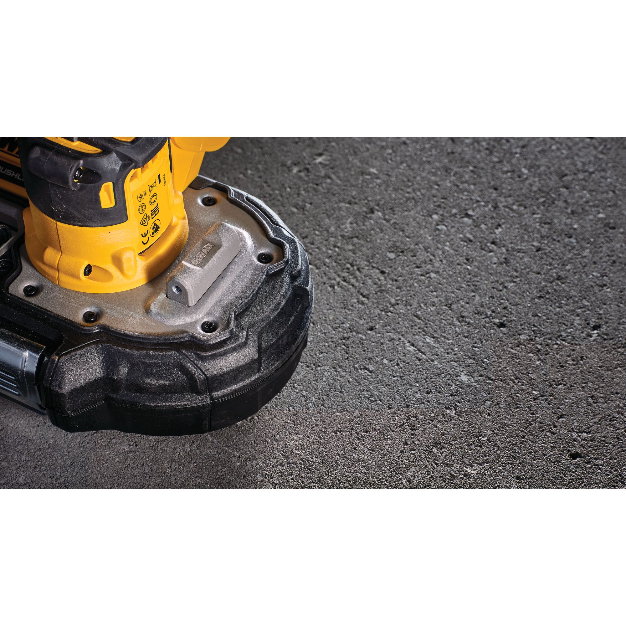Close-up of the DEWALT DCS377NT power tool resting on a rough concrete surface.
