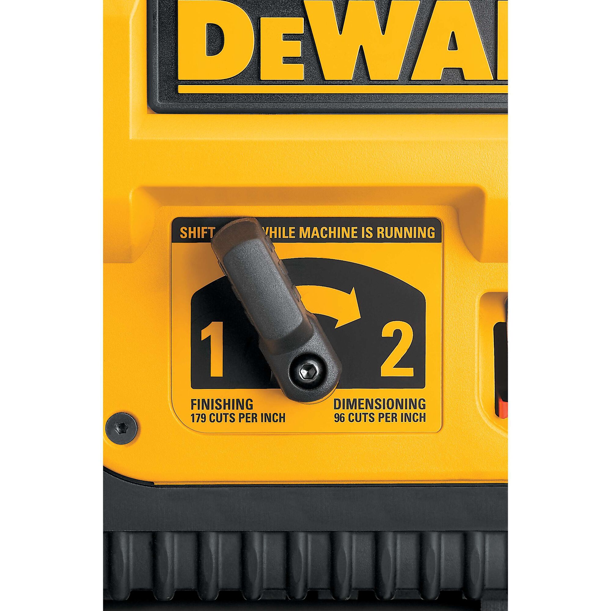 Close-up view of the DEWALT DW735 planer’s control panel showing a yellow and black switch with options for 'Finishing' and 'Dimensioning,' displaying cuts per inch settings.