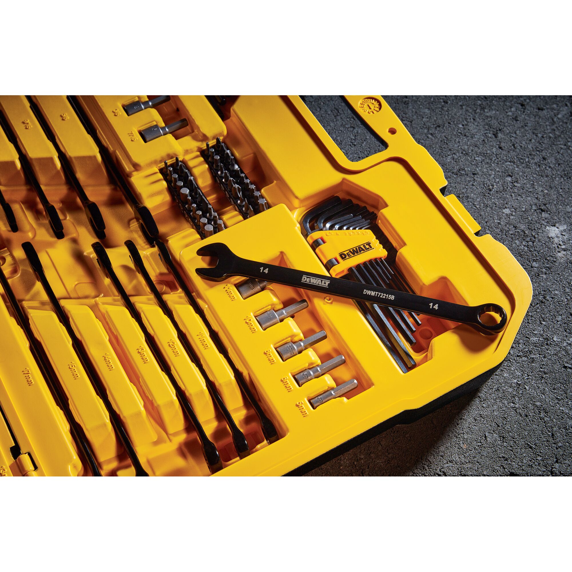 A close-up view of a yellow DEWALT tool set case containing various tools including wrenches, hex keys, screwdriver bits, and other hand tools organized neatly inside the case.