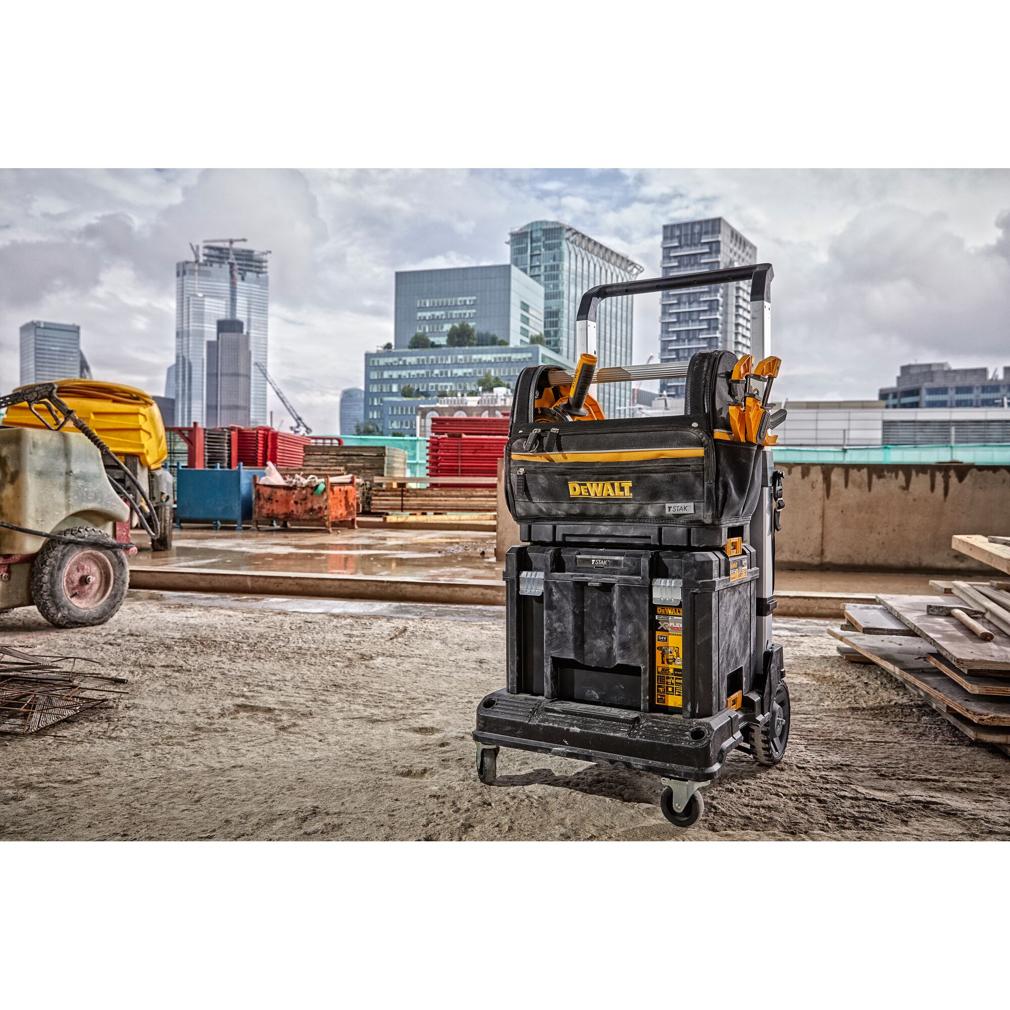 DEWALT mobile tool storage cart loaded with tools, positioned on a construction site with city buildings visible in the background.