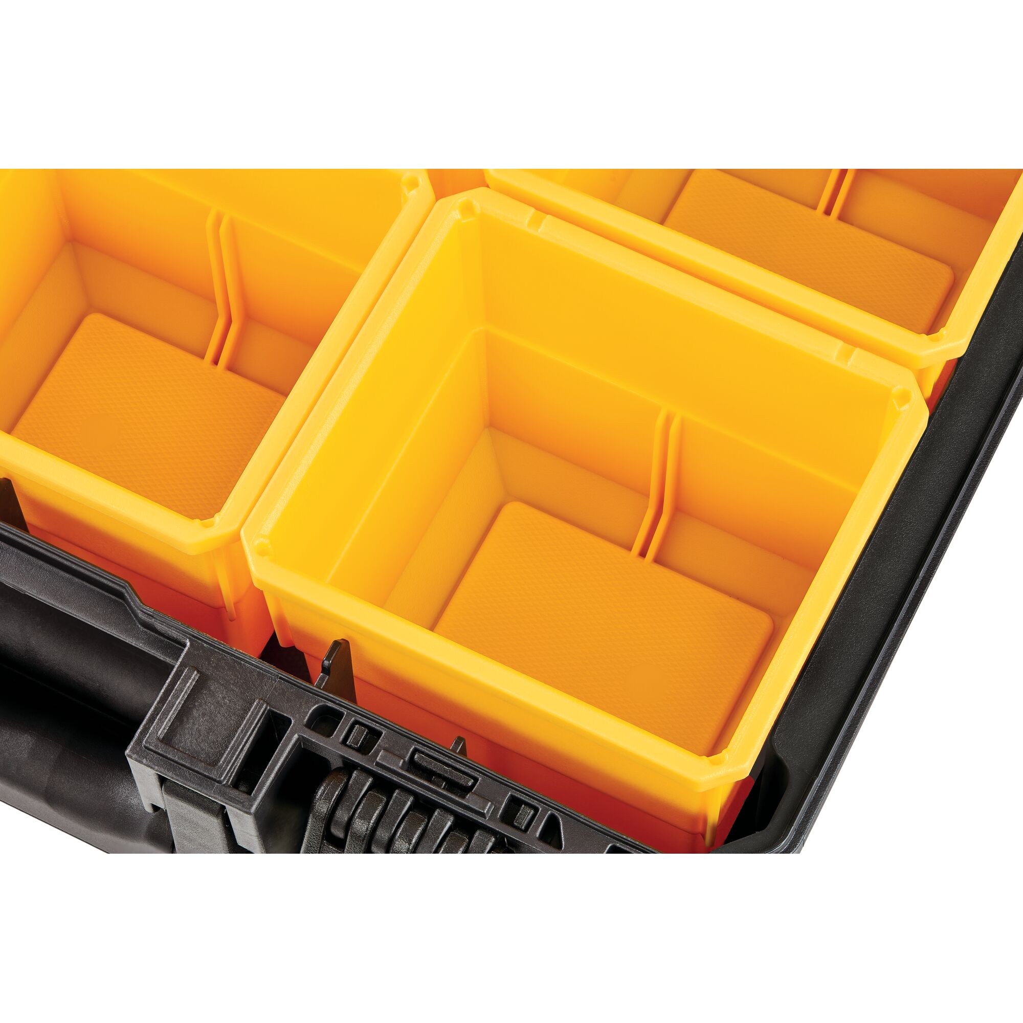Close-up view of yellow plastic organizer compartments inside a black DEWALT storage box.